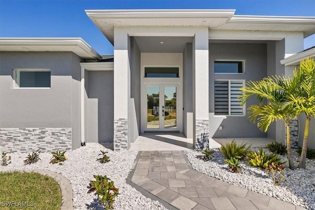 entrance to property featuring stucco siding and french doors