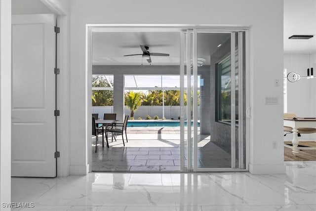 doorway to outside featuring a ceiling fan and marble finish floor