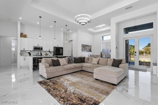 living area with recessed lighting, visible vents, a high ceiling, and marble finish floor