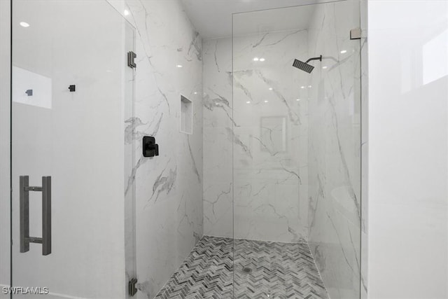 bathroom featuring a marble finish shower