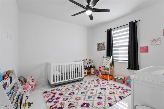 bedroom with a crib and a ceiling fan