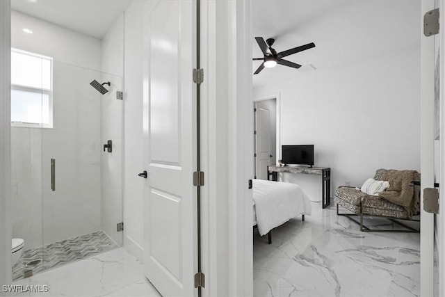 bathroom with marble finish floor, a stall shower, toilet, and a ceiling fan