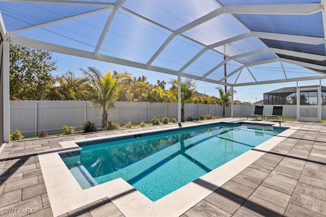 view of pool featuring a patio area, a fenced in pool, glass enclosure, and a fenced backyard