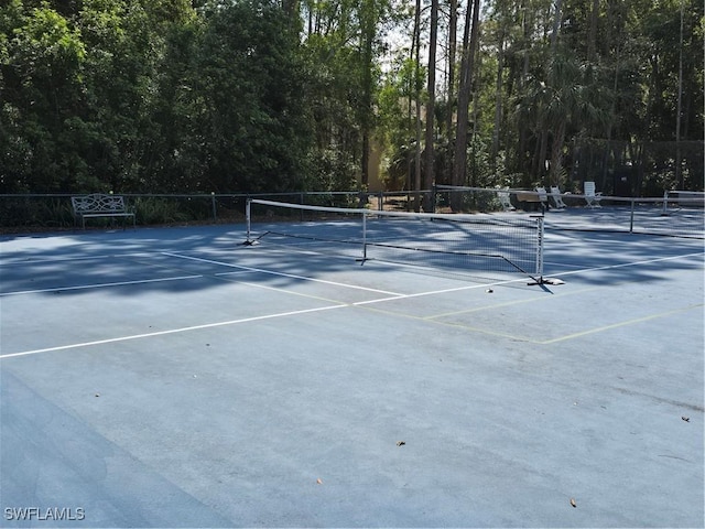 view of tennis court featuring fence