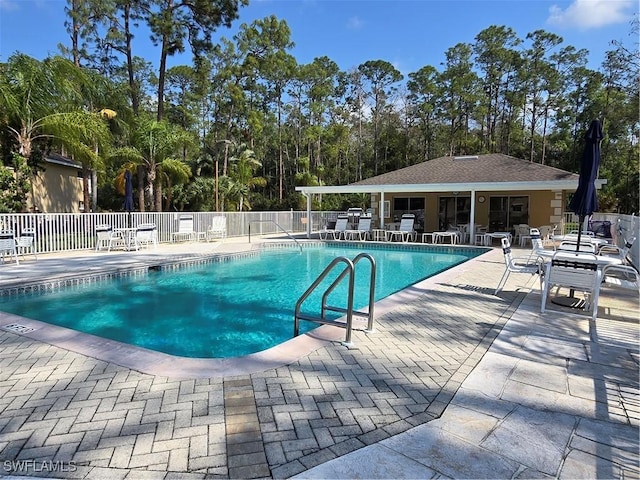 pool with a patio and fence