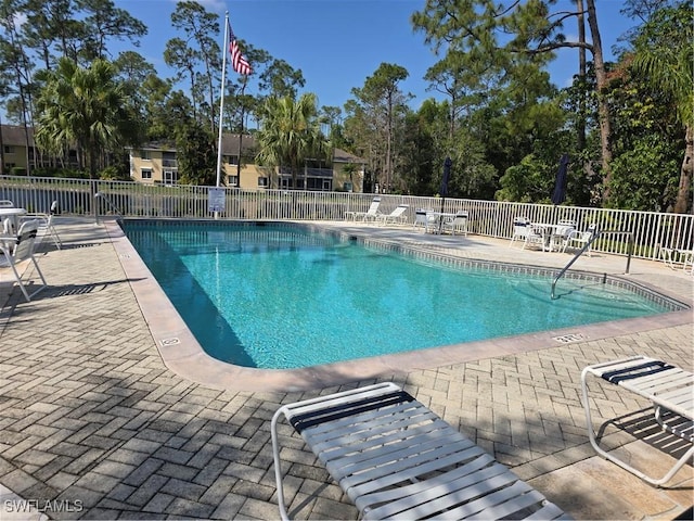 community pool featuring a patio and fence