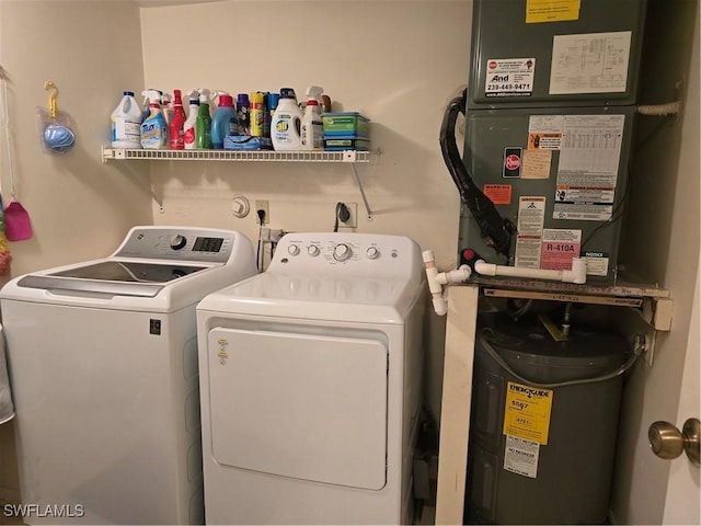 laundry room with heating unit, washing machine and dryer, and laundry area