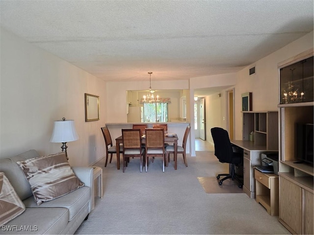 living area with a textured ceiling, a notable chandelier, visible vents, and light carpet