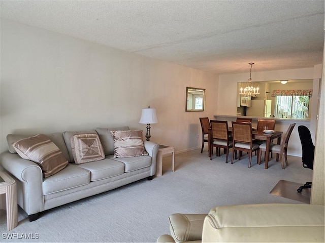 living area with baseboards, carpet, an inviting chandelier, and a textured ceiling