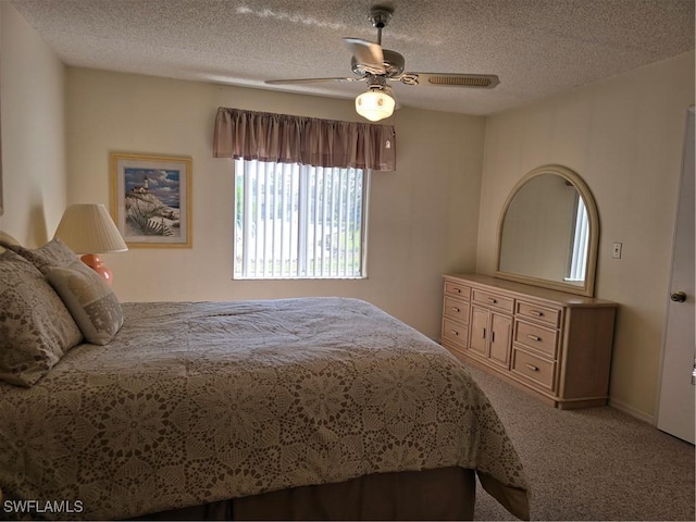 carpeted bedroom with a textured ceiling and ceiling fan