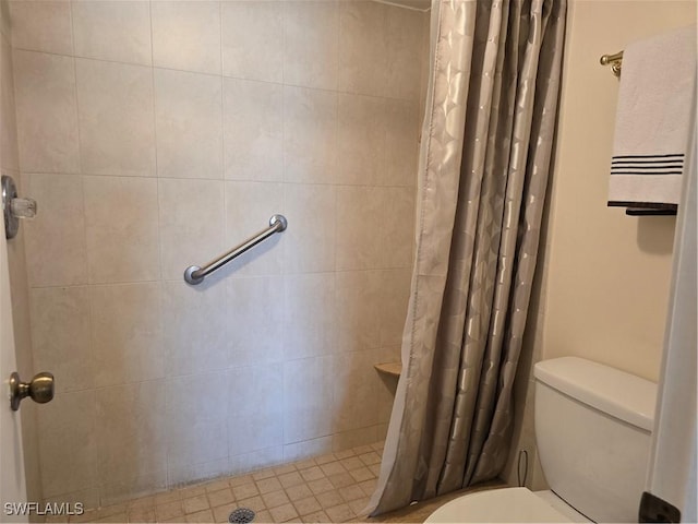 bathroom with tiled shower and toilet