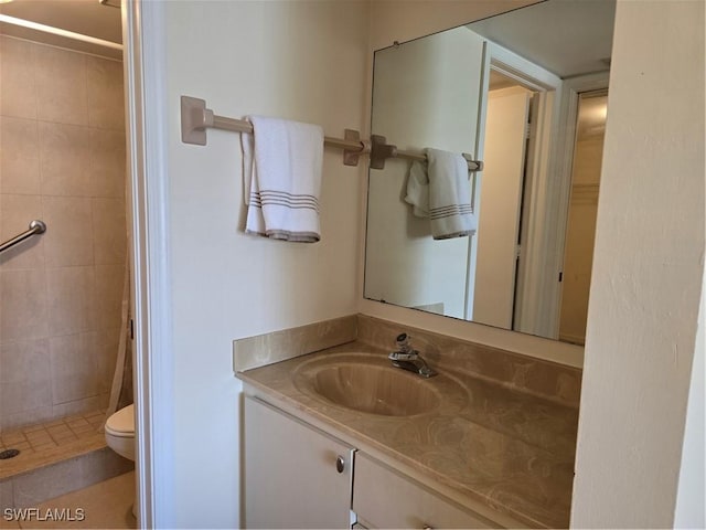 bathroom featuring toilet, a stall shower, and vanity