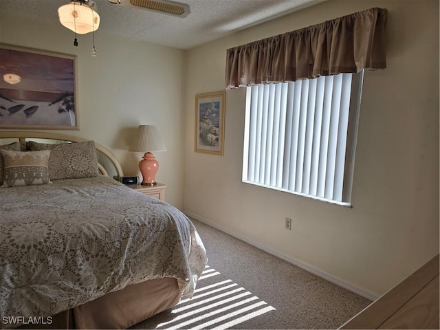 bedroom with baseboards, carpet, and a textured ceiling