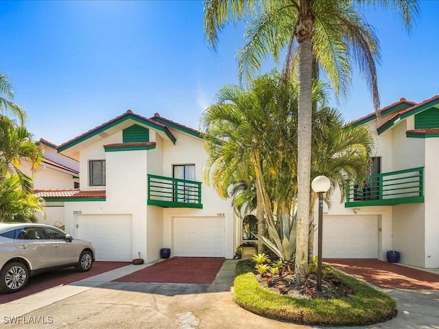 view of front of home featuring a balcony, stucco siding, driveway, and a garage