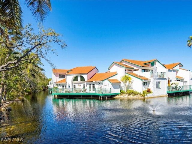 rear view of house with a water view and a residential view