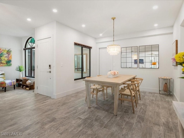 dining space with a notable chandelier, recessed lighting, baseboards, and wood finished floors