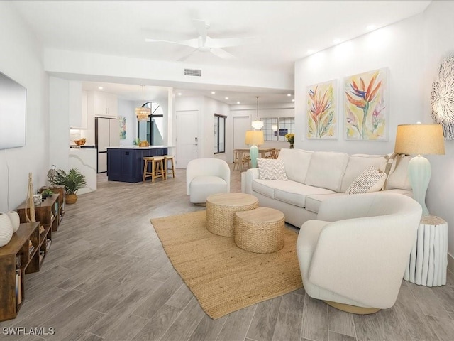 living area with light wood-style flooring, recessed lighting, a ceiling fan, and visible vents