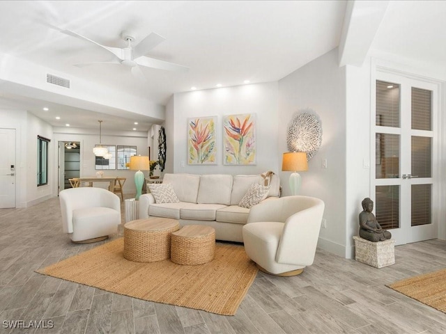 living area featuring wood finished floors, baseboards, visible vents, recessed lighting, and ceiling fan