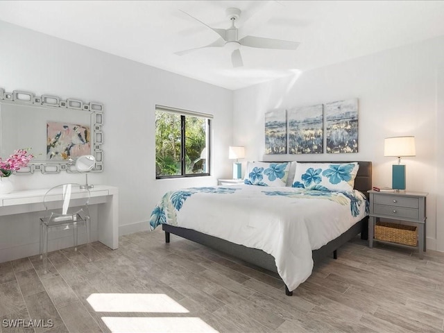 bedroom with baseboards, wood finished floors, and a ceiling fan