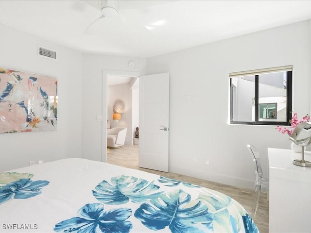 bedroom featuring visible vents, baseboards, and wood finished floors