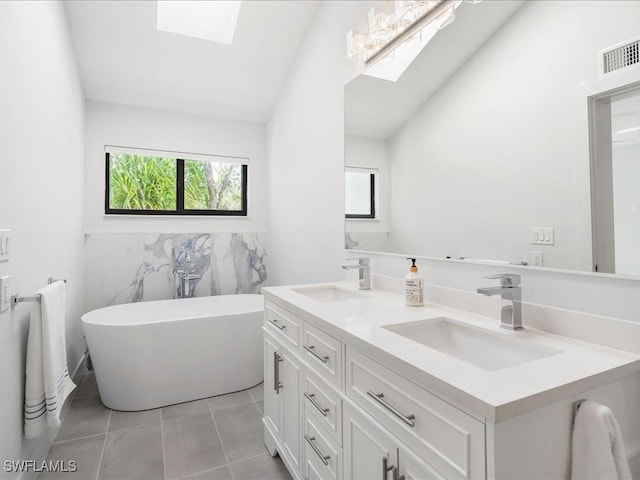 full bathroom with a sink, visible vents, a freestanding bath, and tile patterned flooring