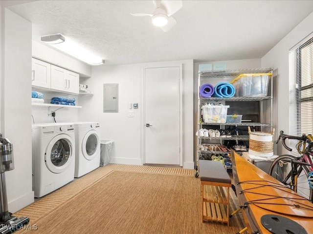 washroom with electric panel, a textured ceiling, washing machine and dryer, cabinet space, and ceiling fan