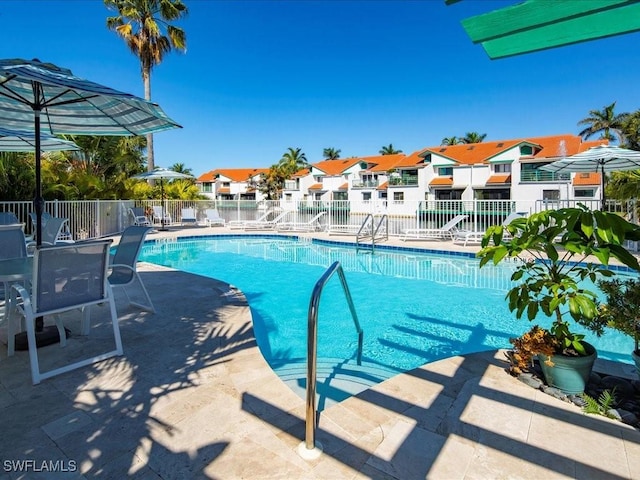 pool featuring a patio area, fence, and a residential view