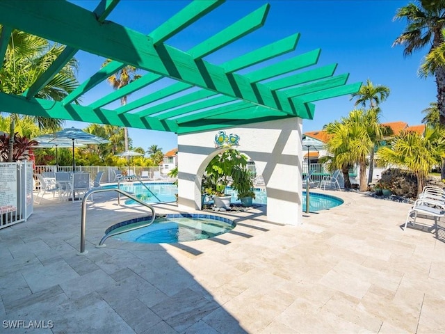 community pool with a patio area, a community hot tub, and fence