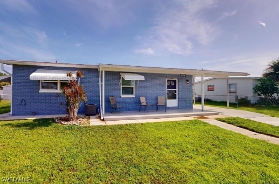 view of front of home featuring brick siding, a front yard, and fence