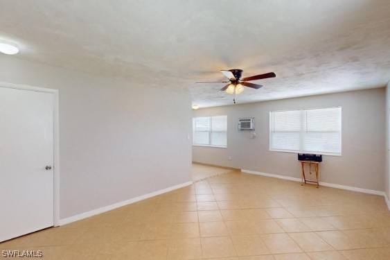 unfurnished room with a textured ceiling, baseboards, and a ceiling fan