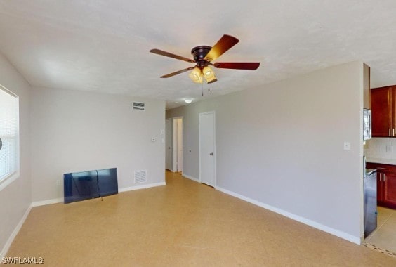 unfurnished room with visible vents, a ceiling fan, and baseboards