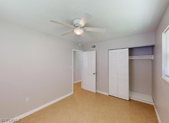 unfurnished bedroom featuring a closet, baseboards, visible vents, and ceiling fan