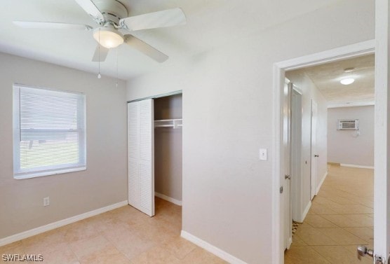 unfurnished bedroom with light tile patterned floors, a closet, baseboards, and ceiling fan