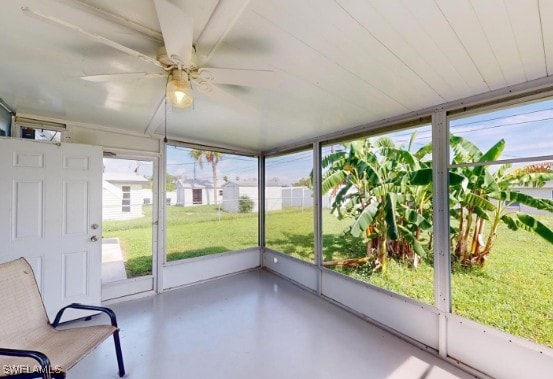 unfurnished sunroom featuring a wealth of natural light and ceiling fan