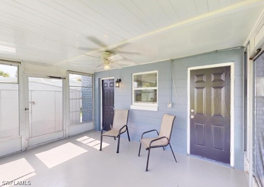 sunroom / solarium featuring a ceiling fan