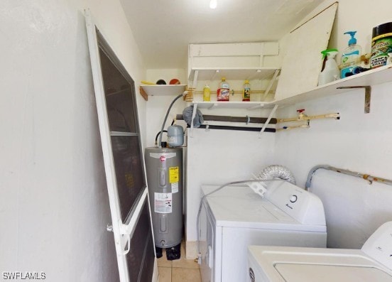 laundry room featuring water heater, laundry area, independent washer and dryer, and light tile patterned floors