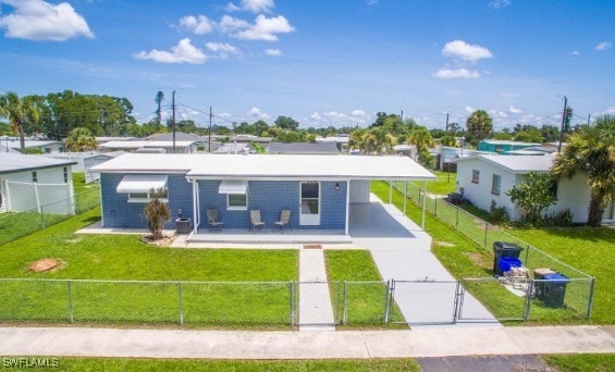 view of front facade featuring a fenced front yard, concrete driveway, a front lawn, and a gate