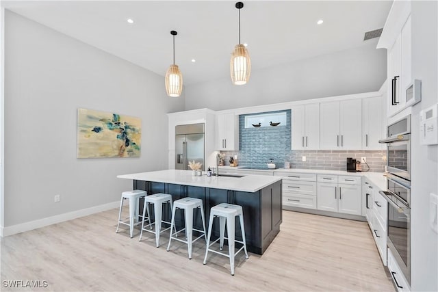 kitchen with a breakfast bar, visible vents, backsplash, appliances with stainless steel finishes, and a sink