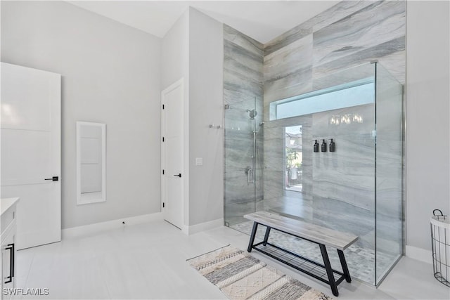 full bathroom with a stall shower, vanity, and baseboards