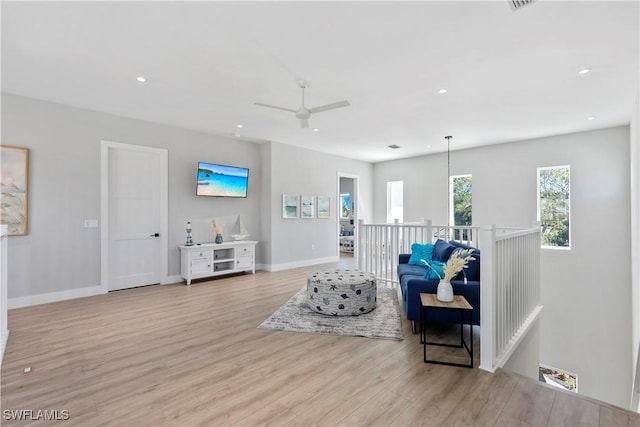 living room with a ceiling fan, recessed lighting, baseboards, and wood finished floors