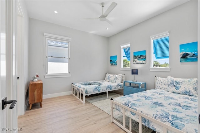 bedroom with recessed lighting, multiple windows, light wood-type flooring, and baseboards