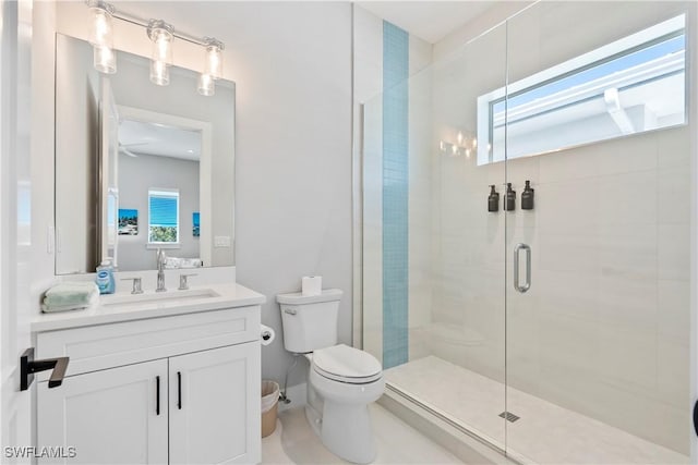 bathroom featuring vanity, a shower stall, and toilet