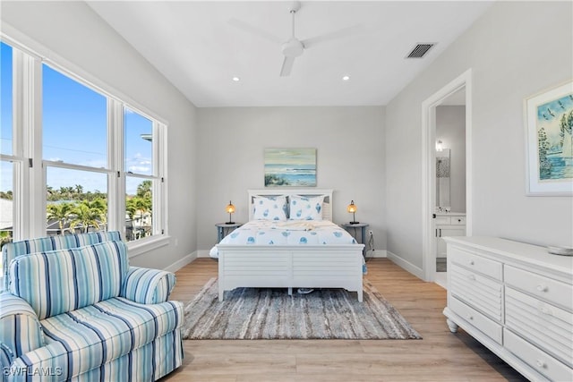 bedroom with visible vents, ensuite bath, light wood-style flooring, and baseboards