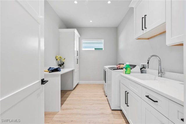 washroom with cabinet space, independent washer and dryer, light wood-type flooring, a sink, and recessed lighting