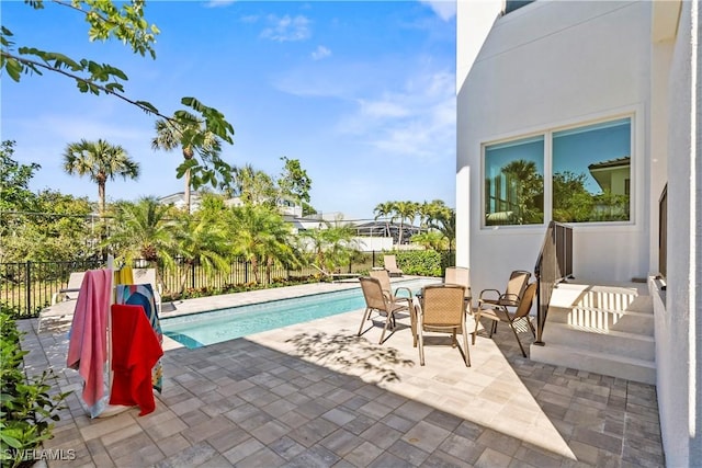 view of pool with outdoor dining area, a patio area, fence, and a fenced in pool