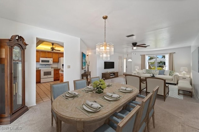 dining area with light carpet, visible vents, ceiling fan with notable chandelier, and light tile patterned floors