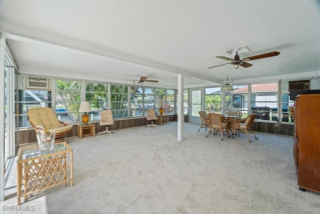 unfurnished sunroom featuring a wall unit AC and a ceiling fan