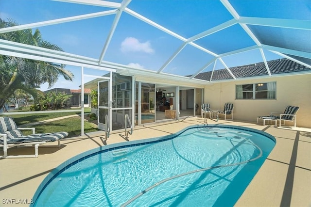 pool with glass enclosure and a patio