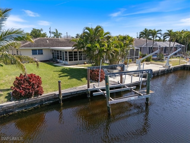 view of dock with glass enclosure, a lawn, a water view, and boat lift