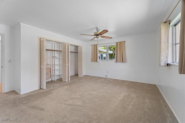 unfurnished bedroom with a closet, carpet floors, baseboards, and a ceiling fan